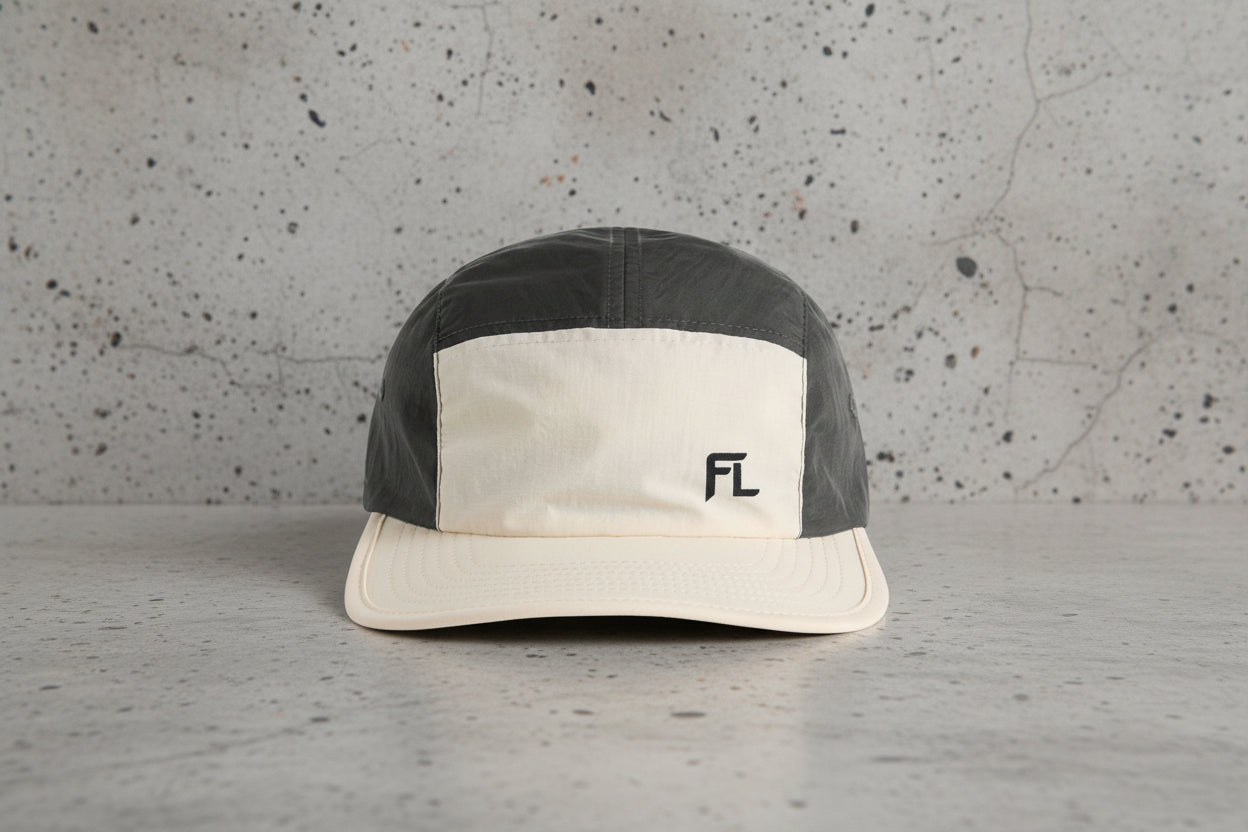 Two-tone black and beige cap with a logo on a white background